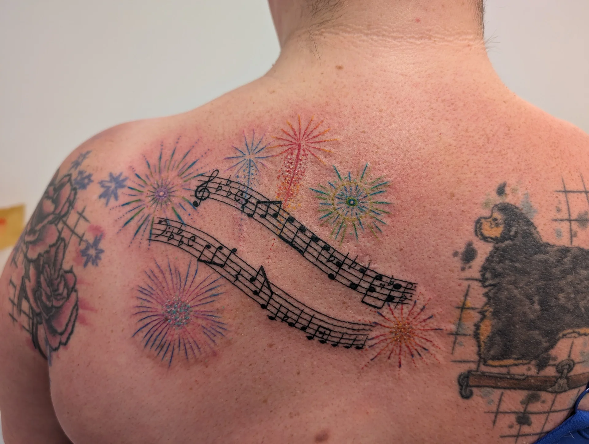 Fireworks Sheet Music Shoulder - illustrative tattoo by Saskatoon tattoo artist