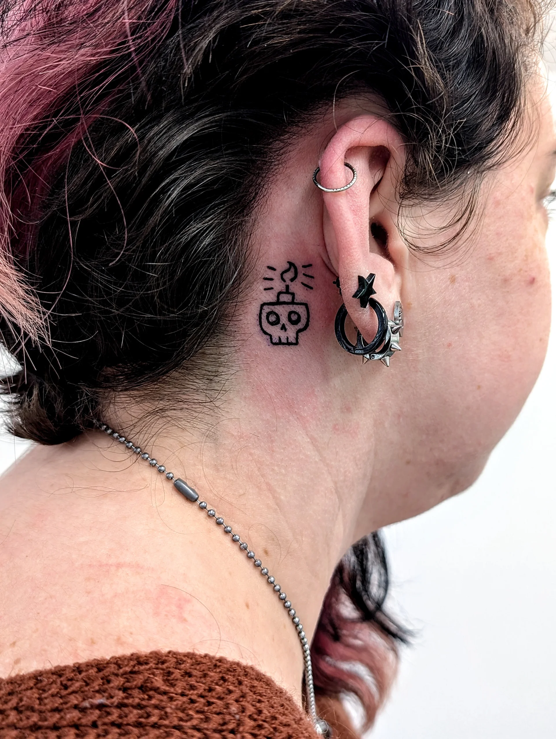 Skull Candle Behind Ear - illustrative tattoo by Saskatoon tattoo artist
