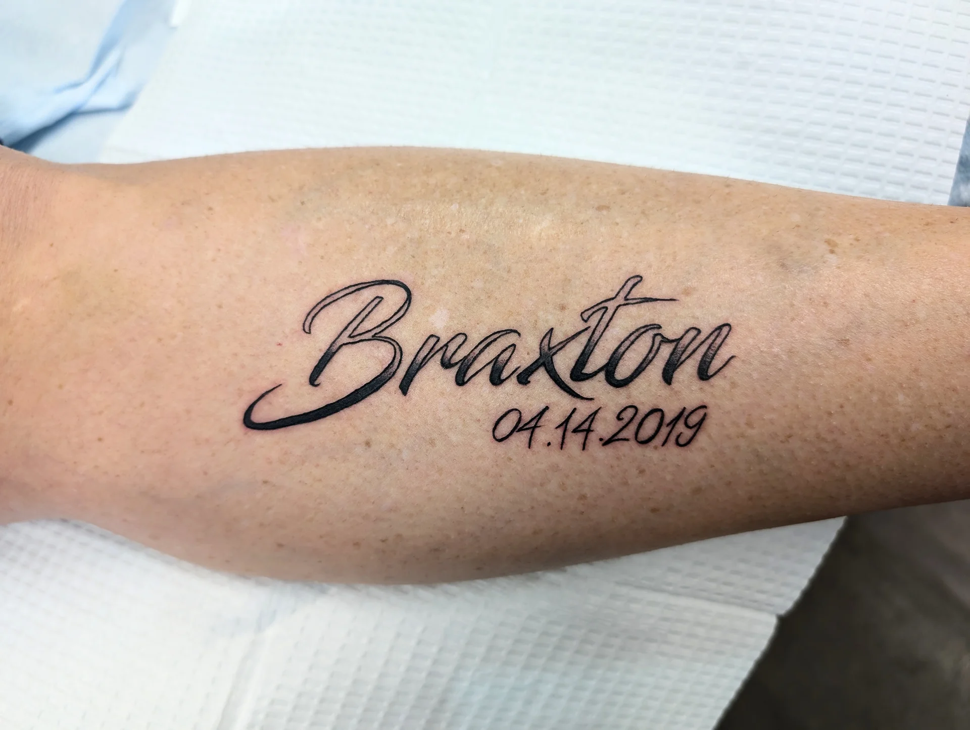 Braxton Name Date - script / lettering tattoo by Saskatoon tattoo artist